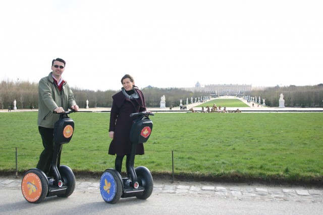 Couple participant à une balade en segway devant la perspective du Château de Versailles