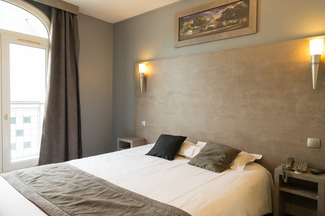 Chambre lumineuse avec lit double et éclairage