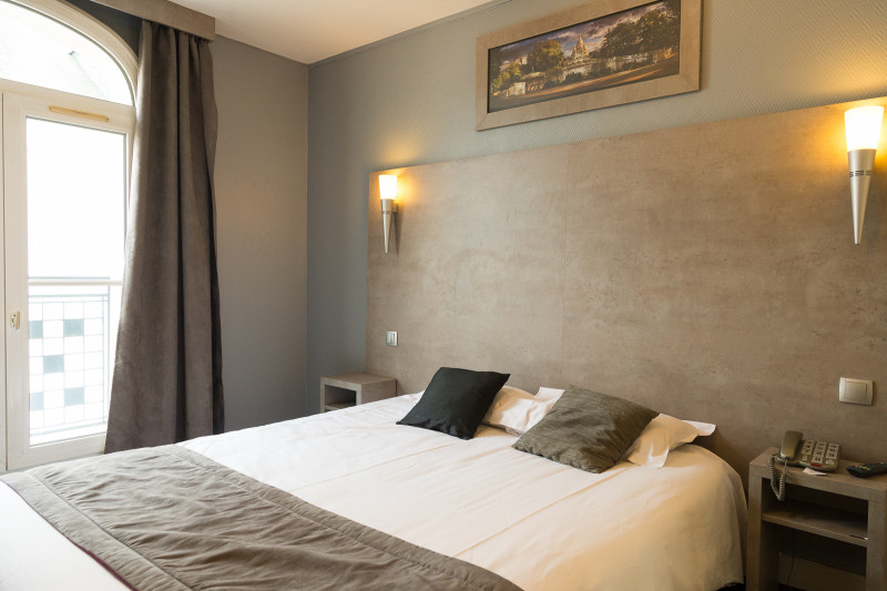 Chambre lumineuse avec lit double et éclairage